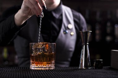 Barmen bir bar ferahlatıcı kokteyl yapmak arka plan. Karanlık moody tarzı. Bu cam buz