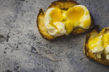 Rustik arka plan mavi gevrek baget tost yumuşak haşlanmış yumurta ve ışık.