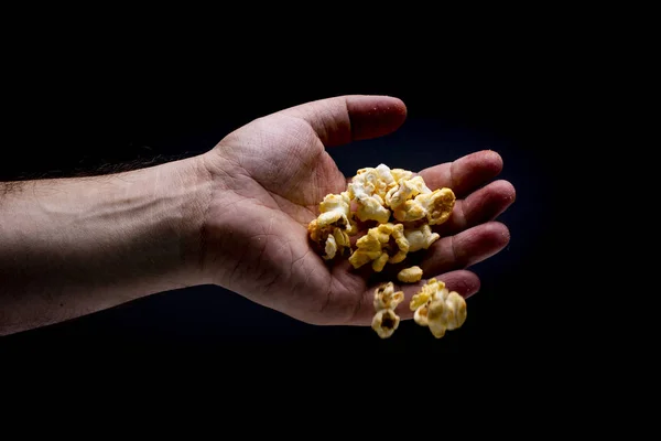 Isolated men hand throwing popcorn isolated on black