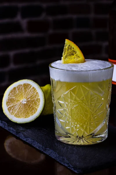 A classic recipe for whiskey sour - with bourbon, cane syrup and lemon juice, garnished with orange. Traditional aperitif. Space for text