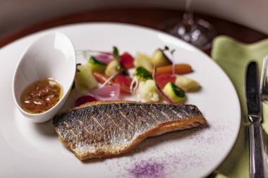 Lezzetli pişmiş levrek balık ve sebze tablo ile plaka