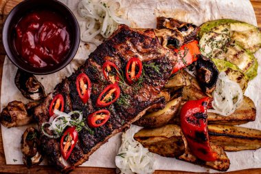 Taze otlar, lahana salatası, eski bir rustik ahşap doğrama tahtasında destekli patates ile deneyimli lezzetli Mangalda kaburga