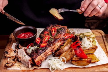 Taze otlar, lahana salatası, eski bir rustik ahşap doğrama tahtasında destekli patates ile deneyimli lezzetli Mangalda kaburga