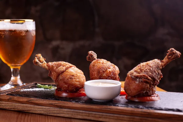 Üç tane tavuk bacağı var. siyah arduvaz üzerinde dur. Siyah arka plan, güzel ışık.