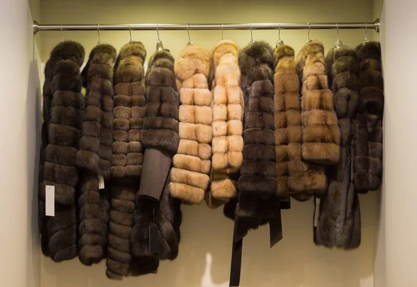 Fur coats on hangers in leather and fur shop.