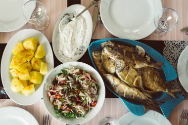 Ev yapımı kızarmış balık. Domates salatası ve haşlanmış patates ile masaya servis.