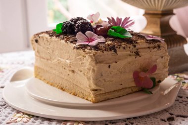 Masanın üzerine ev yapımı lezzetli kremalı pasta. Yakın görüntü. Çiçekler.