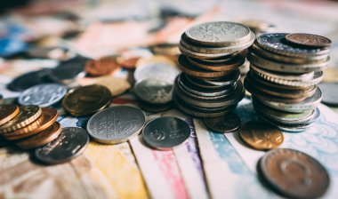 Masaya yayılmış çeşitli sikkelerin üst görünümü.