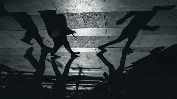 Shadow of people walking in the street.