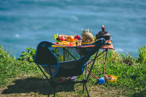 Small picnic table with fruits by the sea Royalty Free Stock Images