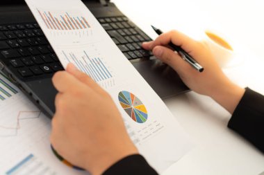 İş kadını masada dizüstü kullanarak mali belgeleri ile