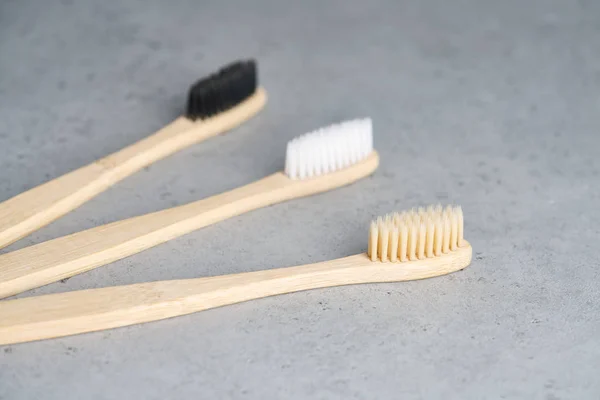 Escovas de dentes de bambu ecológicas em fundo de concreto — Fotografia de Stock