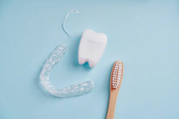 Ecological bamboo toothbrush, mouth guard and dental floss on blue — Stock Photo, Image