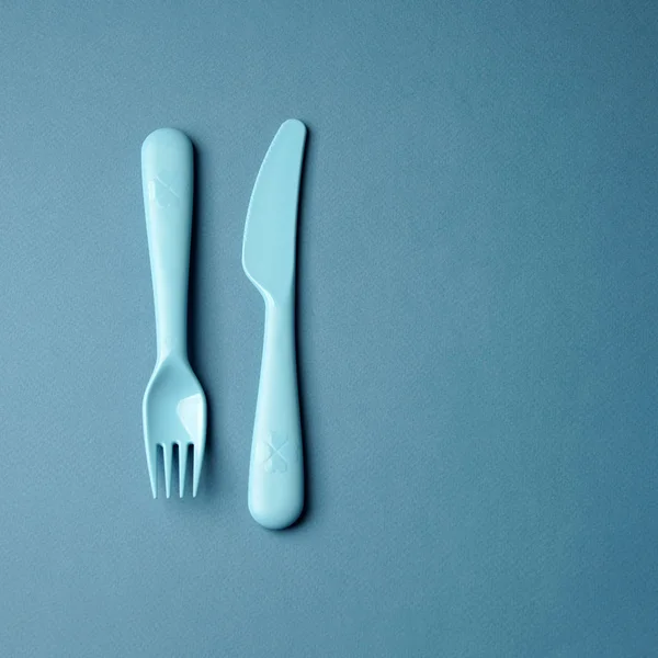 Голубая пластиковая посуда на синем фоне. Концепция — стоковое фото