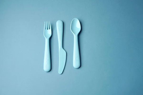 Blue plastic dishes on blue background. Concept — Stock Photo, Image
