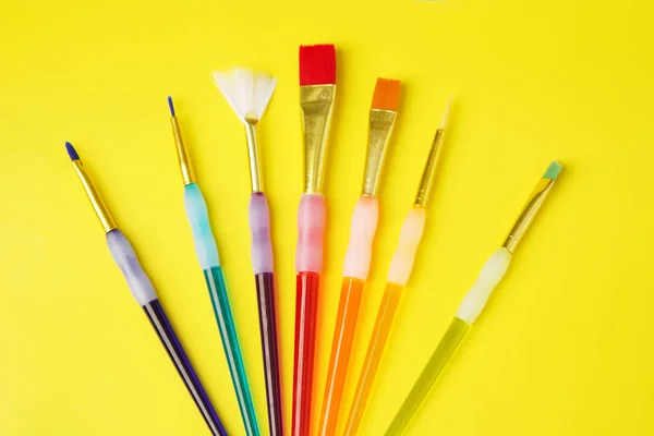 Conjunto colorido de escova no fundo amarelo — Fotografia de Stock