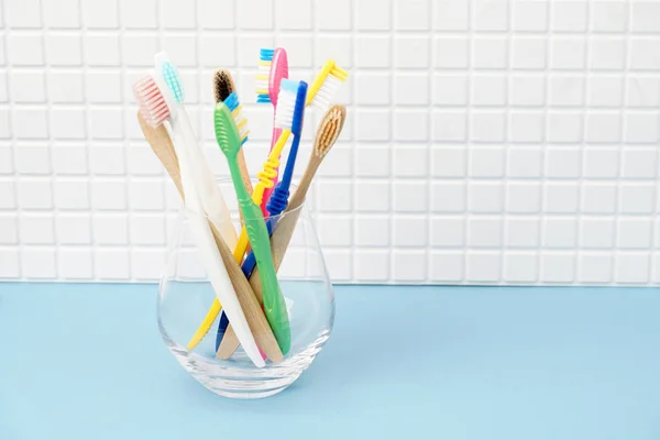 Tandenborstels in glazen beker in badkamer — Stockfoto