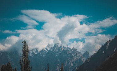 Alçak bulutlar ve güneşli hava ile dağların Manzara