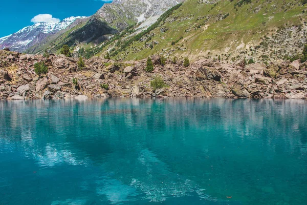 Güneşli hava ile dağlar tarafından yansıtıcı göl Manzara