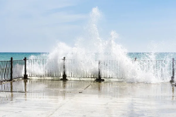 Big waves crushing on curved stone pier, on sunnny weather, big tide. — Stock Photo, Image