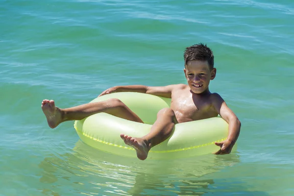 Niño con anillo inflable en el mar —  Fotos de Stock