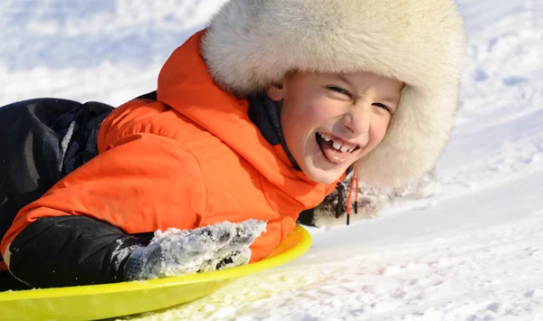 A Boy Smiling Laying on his Sled, Close-up portrait. Winter fun — Stock Photo, Image