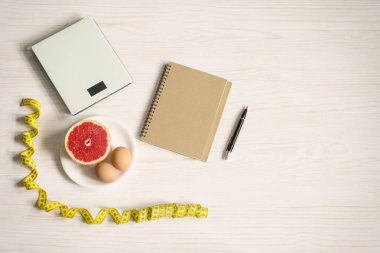Yumurta ve greyfurt diyet kavramı. Beyaz ahşap arka plan ağırlık ölçekte. üstten görünüm ve kopya alanı
