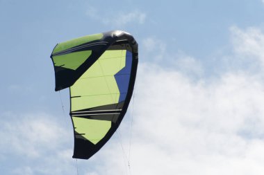 Kiteboarding uçurtma yakın çekim mavi gökyüzü bulutlu arka planda.