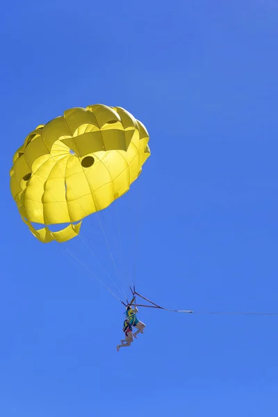 Pareja activa joven disfrutando de volar con paracaídas, actividad extrema de parasailing — Foto de Stock