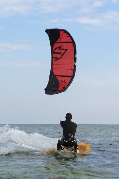 Kitesurfing. Man rides a kite in the sea