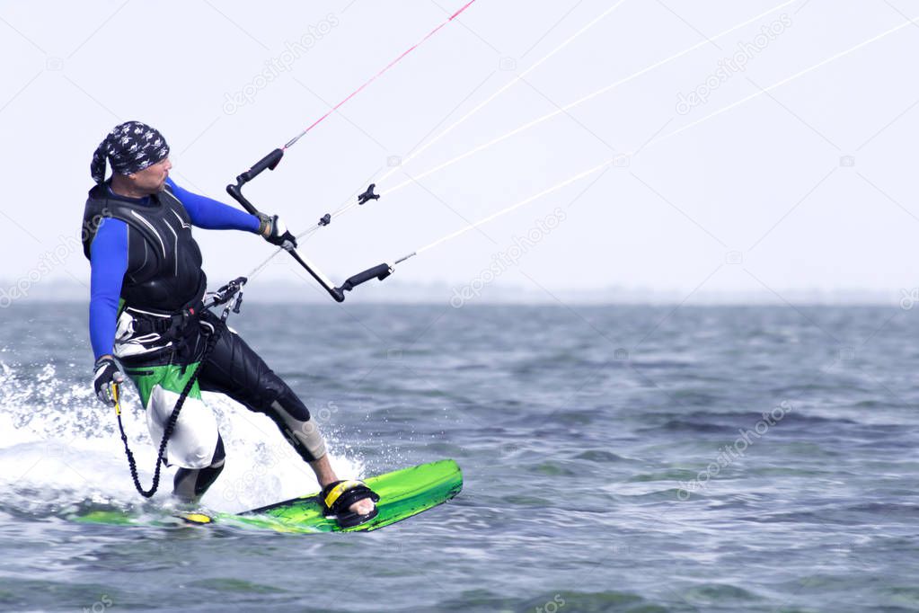 Kitesurfing. Man rides a kite in the sea