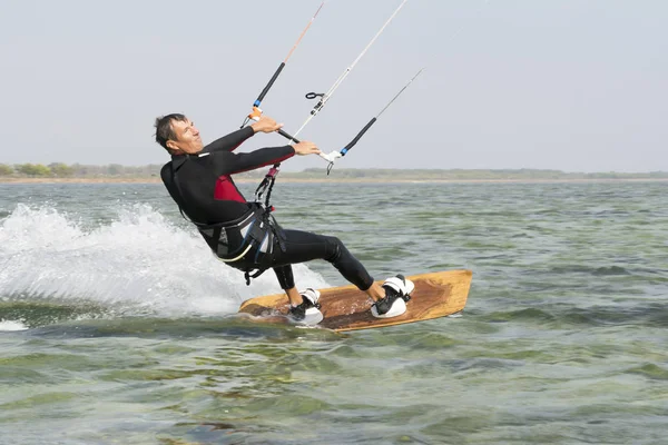 Kitesurfing. Man rides a kite in the sea — Stock Photo, Image