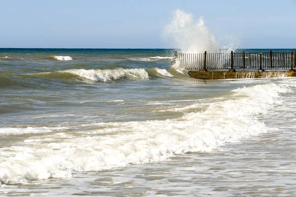 Seascape with stormy waves and old stone pier. Water splashes — Stock Photo, Image
