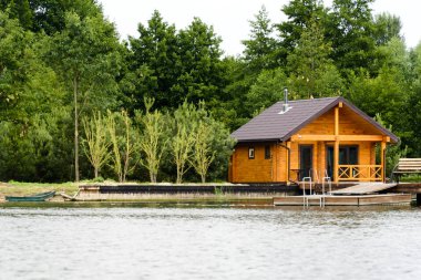 Etkileyici göl evi. Ev nehir kıyısında. Su yansıtıyordu. Kırlarda, orman ve göl evi ile.
