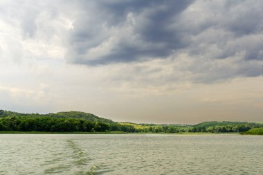 yeşil çayır, geniş nehir ve yağmur önce bulutlu gökyüzü manzara