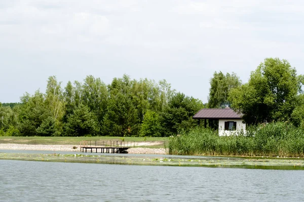Impressionante casa do lago. Casa na margem do rio. Refletindo sobre a água. Lado do país, floresta e lago com casa . — Fotografia de Stock