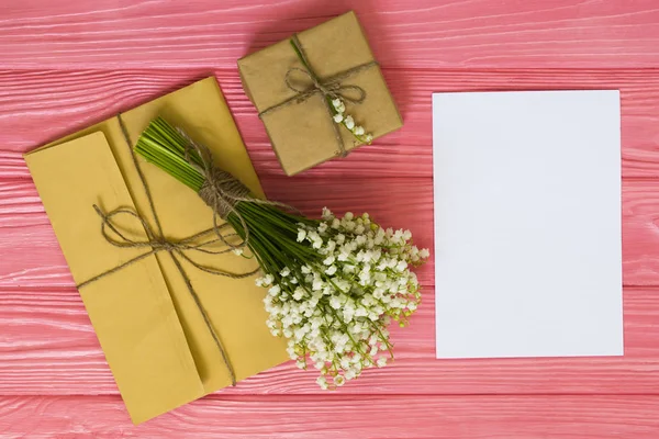 Mockup with bouquet and empty greeting card, gift box, envelope top view, copy space for text, flat lay
