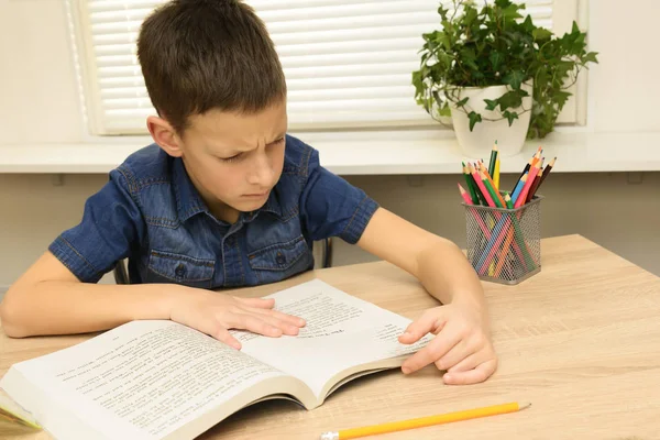Ev ödevi yaparken konsantre küçük çocuk okuma kitabı — Stok fotoğraf