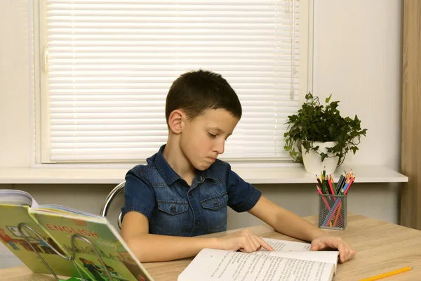 Evde okuyan genç okul çocuğu. Çocuk ödev yapıyor. — Stok fotoğraf