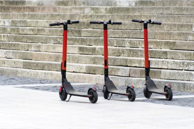 Otoparkta arka arkaya elektrikli scooterlar. Şehir bisiklet kiralama sistemi, sokakta halka açık scooter 'lar.