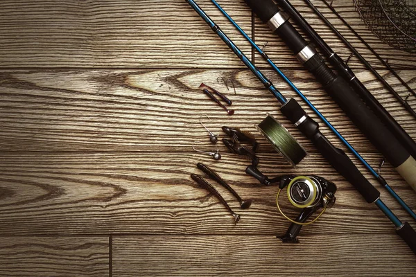 Aparejos de pesca - pesca spinning, anzuelos y señuelos sobre fondo de madera oscura. Vista superior . — Foto de Stock