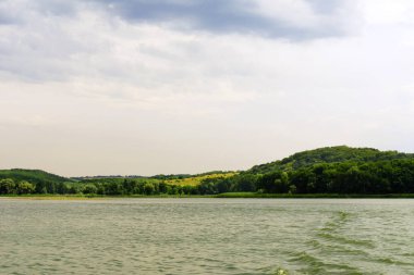 yeşil çayır, geniş nehir ve yağmur önce bulutlu gökyüzü manzara