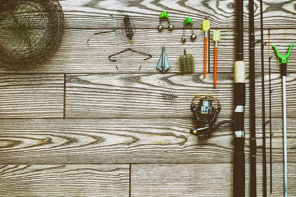 Fiske mataren och hjul. Fiskeredskap bakgrund. Fiske feeder-krokar och beten på mörkare trä bakgrund. — Stockfoto