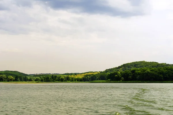 yeşil çayır, geniş nehir ve yağmur önce bulutlu gökyüzü manzara