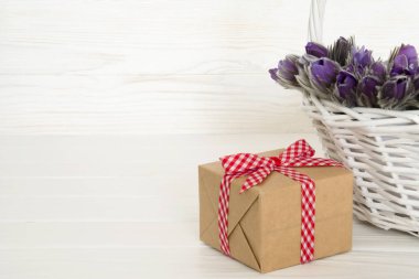 Hediye ve mor Anemon metin için boşluk ile beyaz arka plan üzerinde sepet içinde. Tebrik kartı