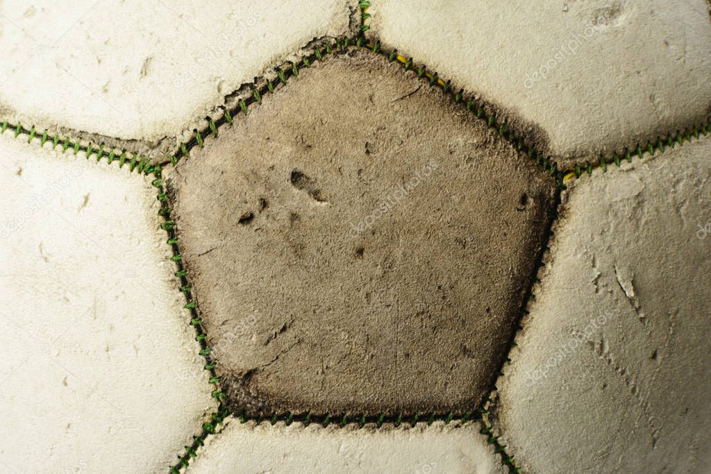 Used vintage soccer ball, close-up background with cracked texture