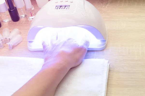 Gel nagel manicure procedure - Vrouw drogen nagels in Led-UV lamp. Kopieerruimte voor tekst — Stockfoto