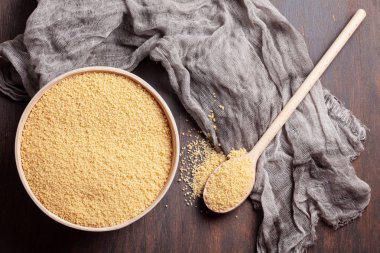 Kabın içinde ham kuskus üstten görünüm koyu ahşap tablo