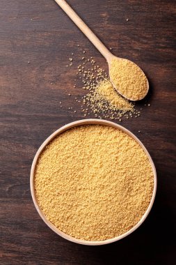 Kabın içinde ham kuskus üstten görünüm koyu ahşap tablo