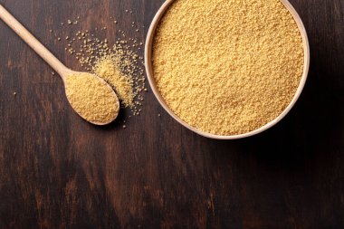 Kabın içinde ham kuskus üstten görünüm koyu ahşap tablo